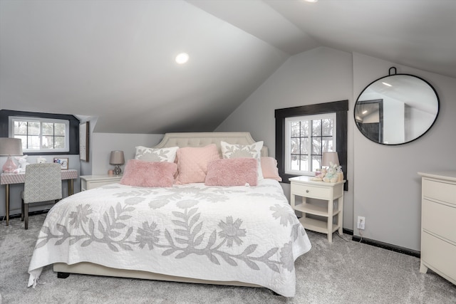 bedroom featuring lofted ceiling, multiple windows, baseboards, and light colored carpet