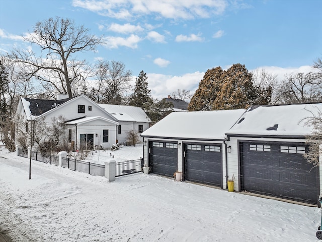 view of front of home featuring a detached garage and fence