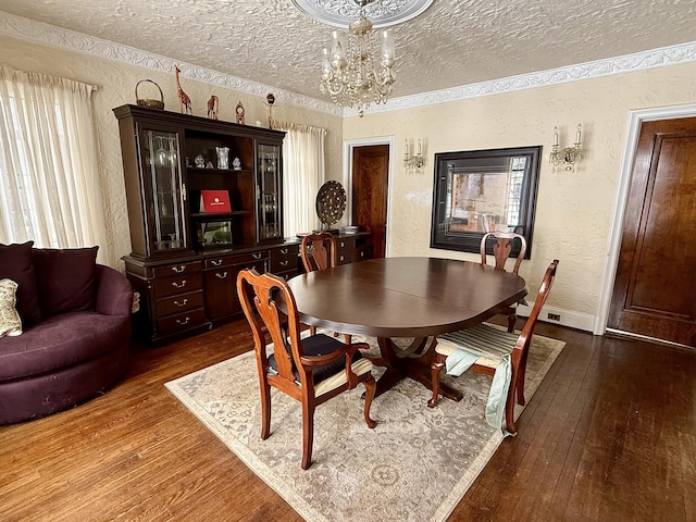 dining area with a textured ceiling, a textured wall, a chandelier, ornamental molding, and dark wood-style floors