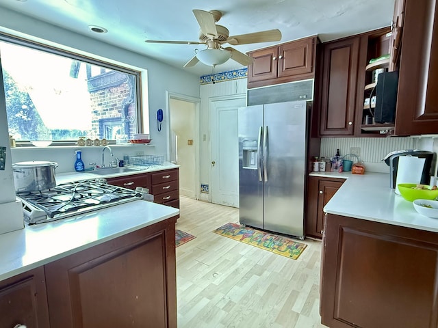 kitchen with a sink, light wood-type flooring, stainless steel appliances, and light countertops