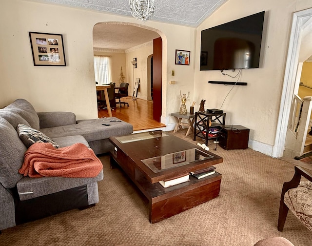 carpeted living area with arched walkways, a textured ceiling, and vaulted ceiling