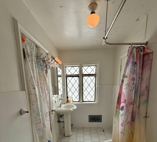 bathroom with visible vents, a sink, and a shower with shower curtain