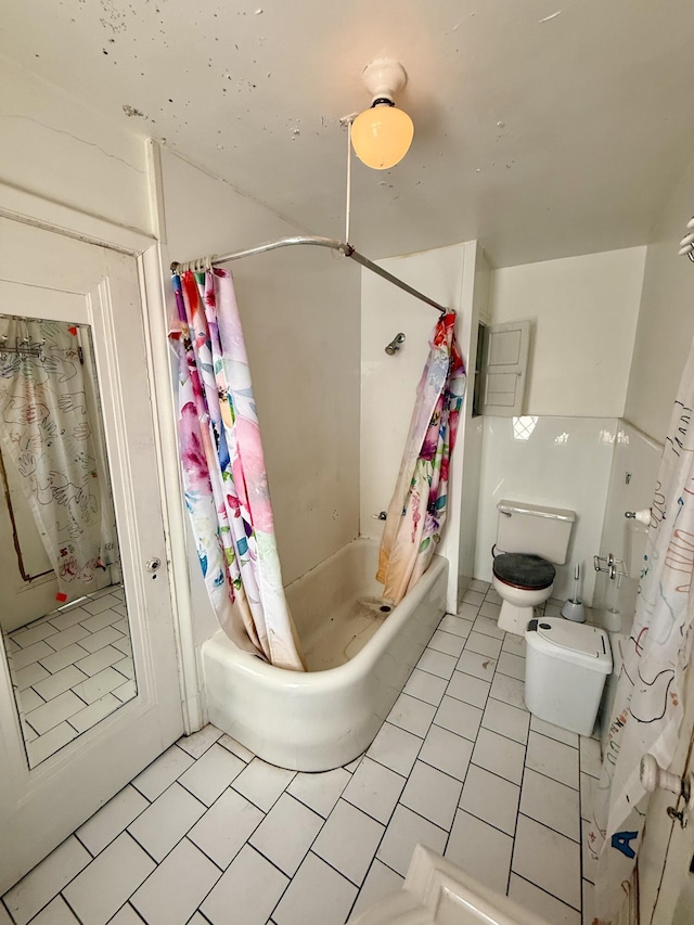 bathroom with shower / bath combo with shower curtain, toilet, and tile patterned floors