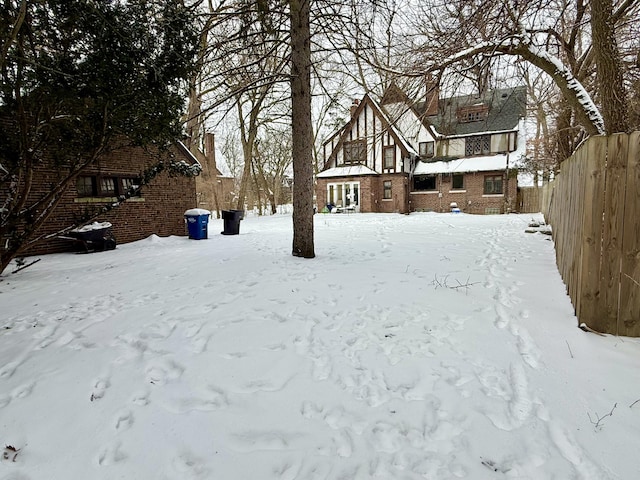 yard layered in snow featuring fence