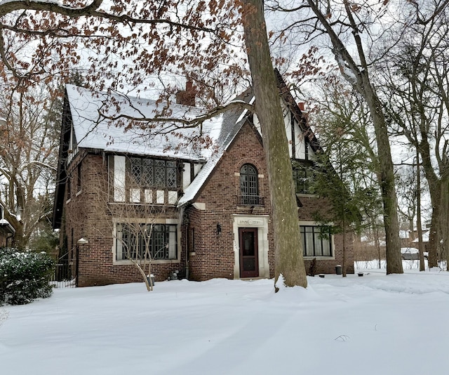 tudor-style house with brick siding and a balcony