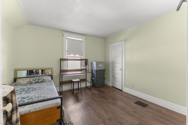 bedroom with dark wood-style floors, baseboards, visible vents, and vaulted ceiling