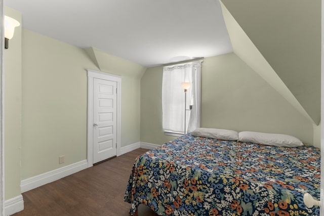 bedroom featuring vaulted ceiling, baseboards, and wood finished floors