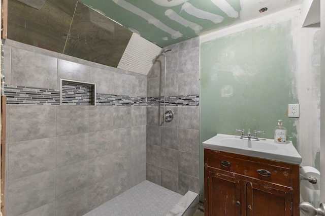 bathroom with a tile shower and vanity