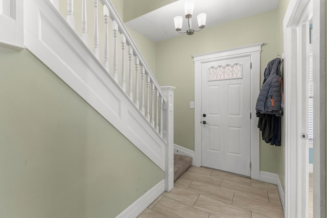 entryway with a chandelier, stairway, and baseboards