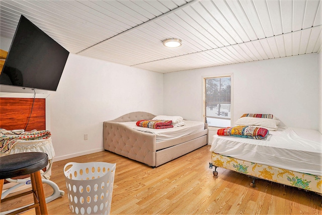 bedroom with wood finished floors, wood ceiling, and baseboards