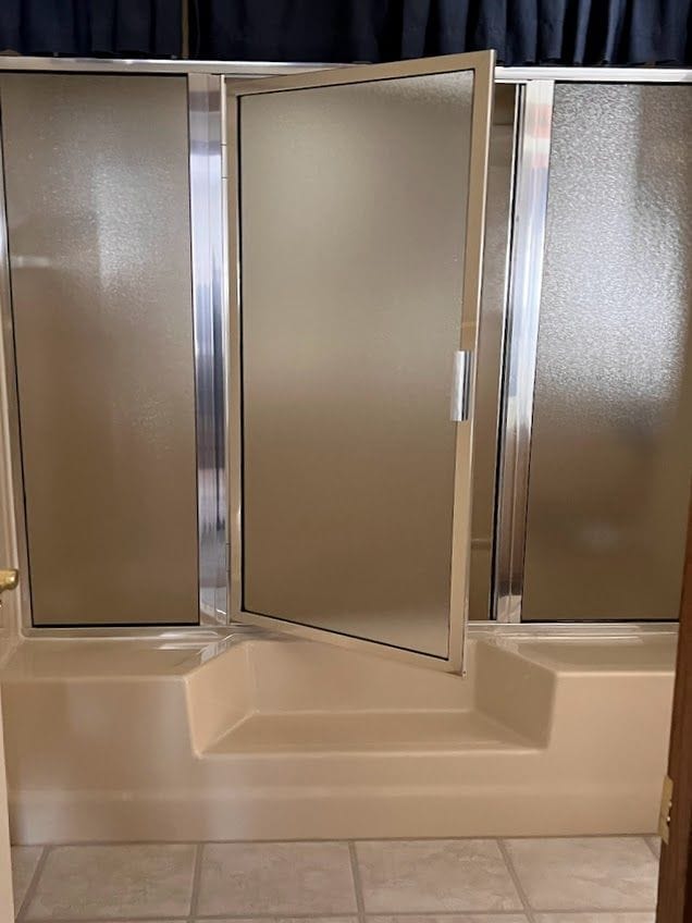 full bathroom with walk in shower and tile patterned flooring