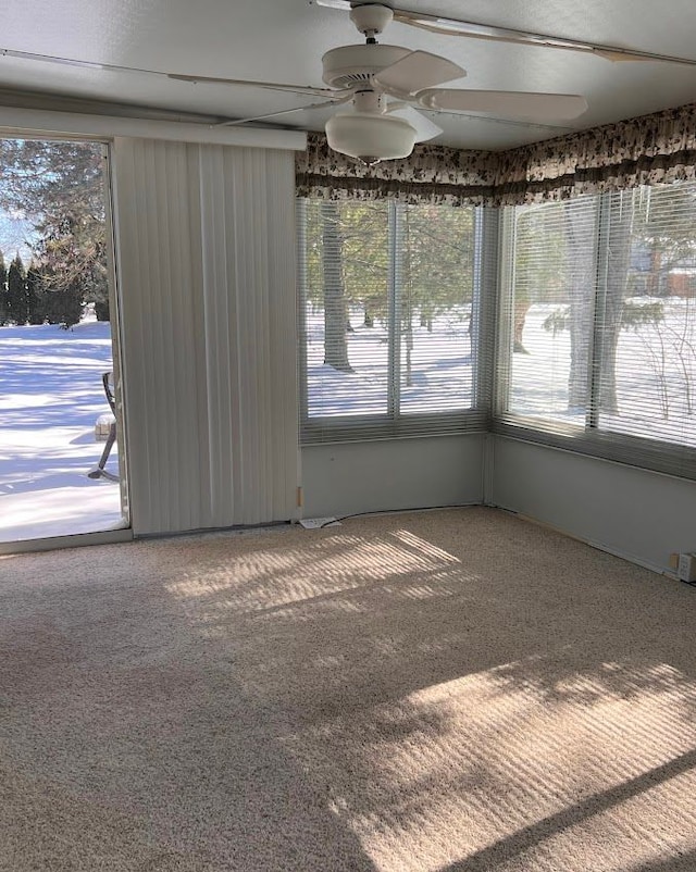 unfurnished sunroom with a ceiling fan