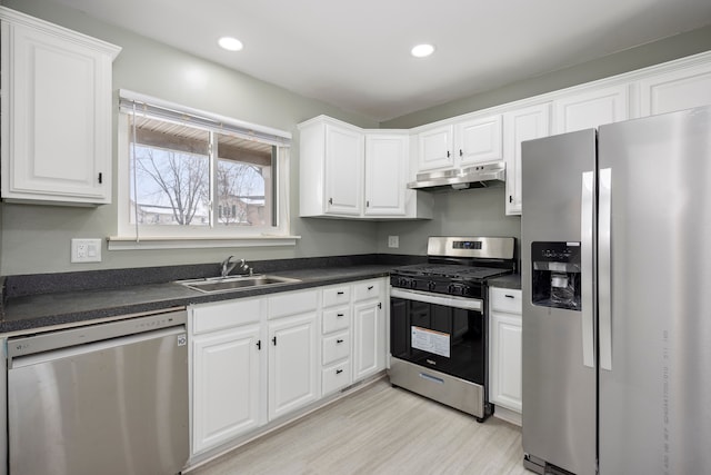 kitchen with under cabinet range hood, appliances with stainless steel finishes, and white cabinets