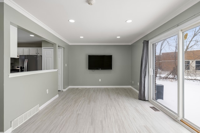 unfurnished living room with light wood finished floors, baseboards, visible vents, and ornamental molding