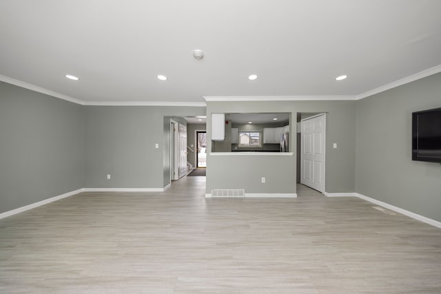 unfurnished living room with light wood finished floors, baseboards, and visible vents