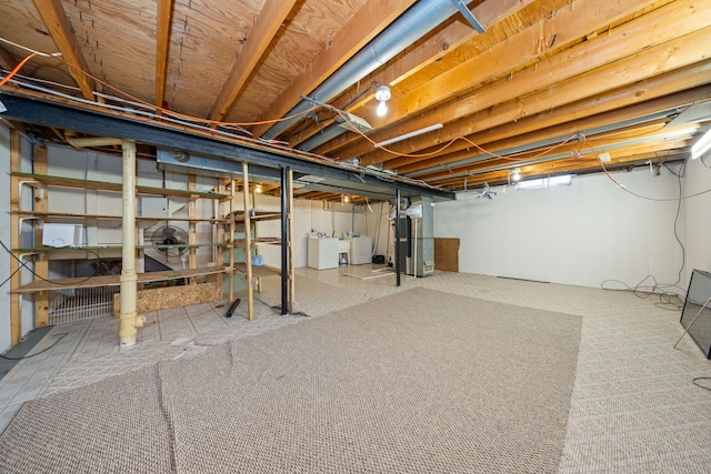 unfinished basement featuring independent washer and dryer and heating unit