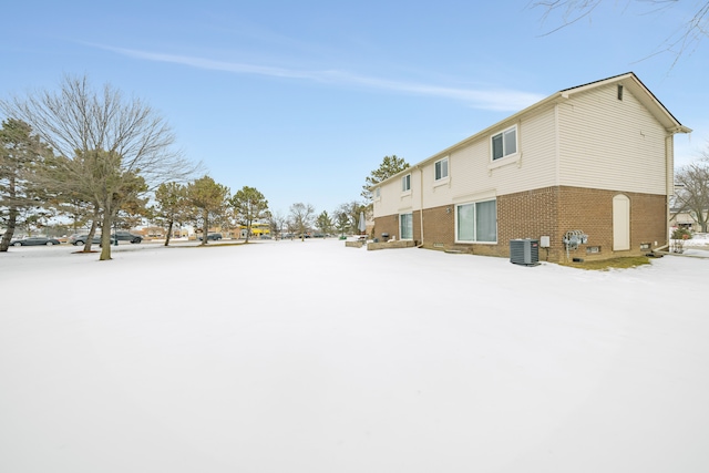 exterior space featuring crawl space, brick siding, and central air condition unit