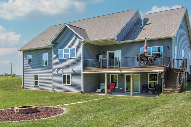 rear view of house featuring a wooden deck, a fire pit, a patio, stairs, and a yard