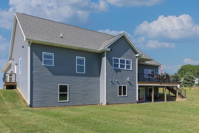 back of property featuring roof with shingles, stairway, a lawn, and a wooden deck