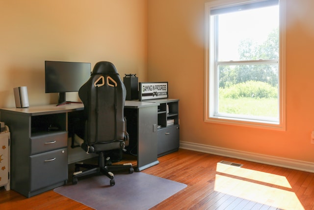 office featuring baseboards, visible vents, and light wood finished floors