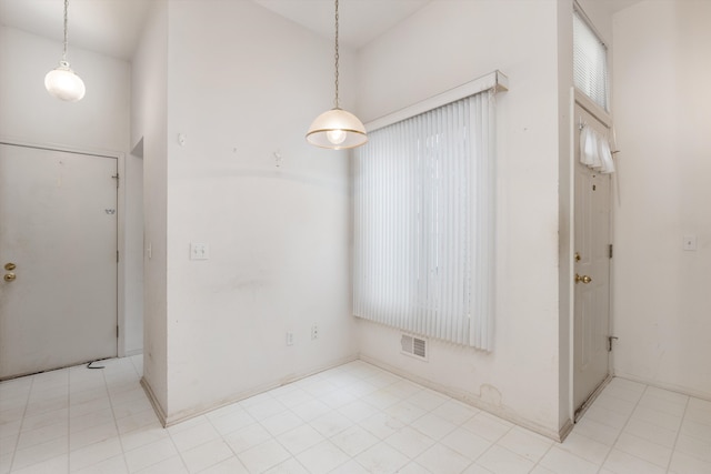 unfurnished room featuring visible vents and a towering ceiling