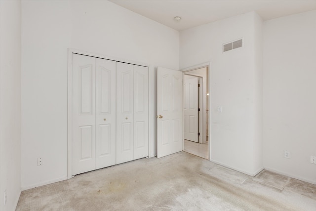 unfurnished bedroom featuring a closet, carpet flooring, visible vents, and baseboards