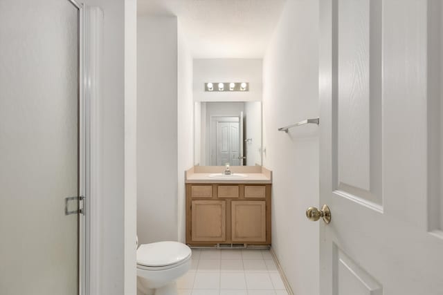 bathroom featuring toilet, a stall shower, tile patterned flooring, and vanity