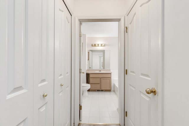 bathroom featuring a closet, vanity, toilet, and tile patterned floors