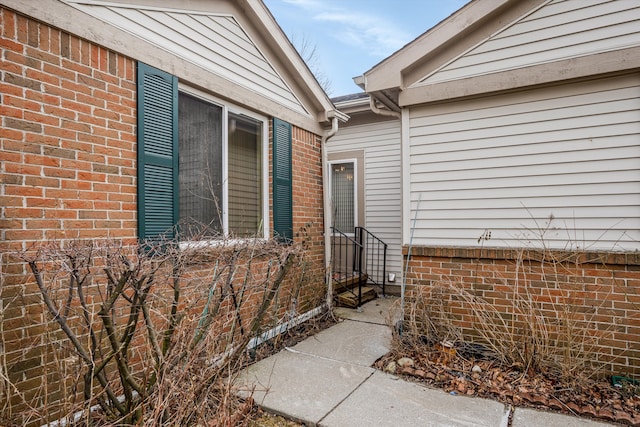 doorway to property featuring brick siding