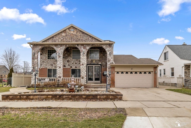 view of front of house with driveway, brick siding, an attached garage, and fence