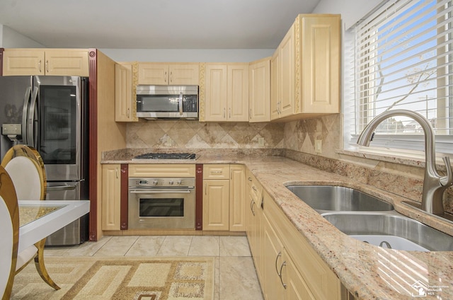 7740 Ternes St, Dearborn, MI 48126 - kitchen with light tile patterned floors, stainless steel appliances, a sink, backsplash, and light stone countertops