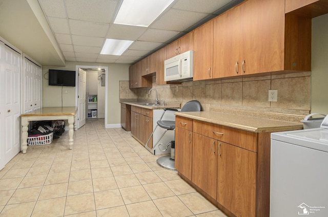 7740 Ternes St, Dearborn, MI 48126 - kitchen with light tile patterned floors, tasteful backsplash, white microwave, washer / clothes dryer, and a paneled ceiling