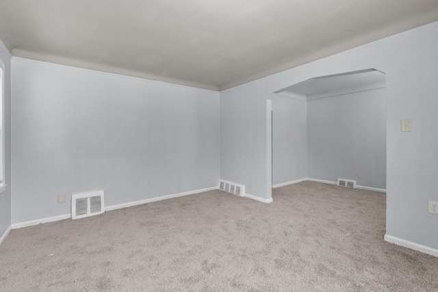 empty room with visible vents, light carpet, and baseboards