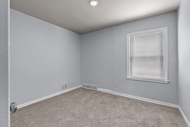 unfurnished room with baseboards, visible vents, and light colored carpet