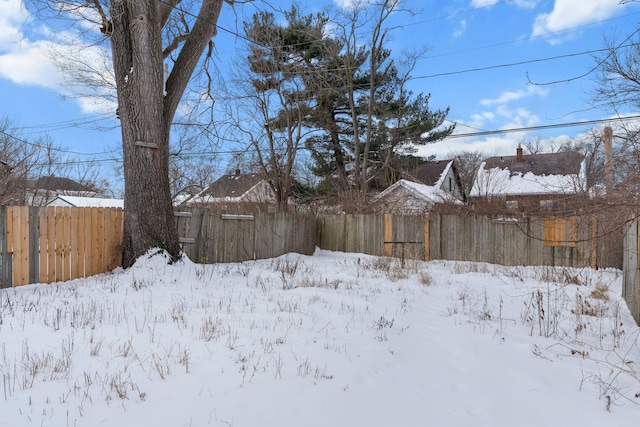 snowy yard featuring fence