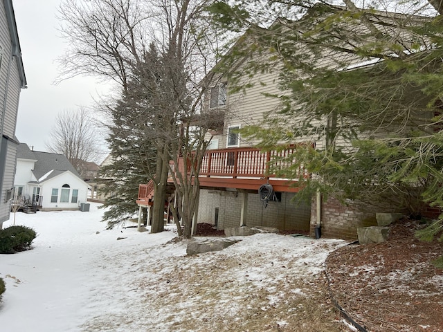 snow covered property with a deck