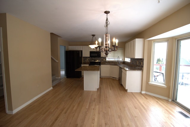 kitchen featuring visible vents, decorative backsplash, white cabinets, a sink, and black appliances