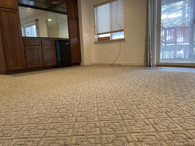 unfurnished room featuring baseboards and light colored carpet