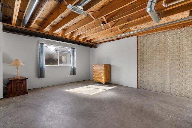 basement with visible vents and brick wall