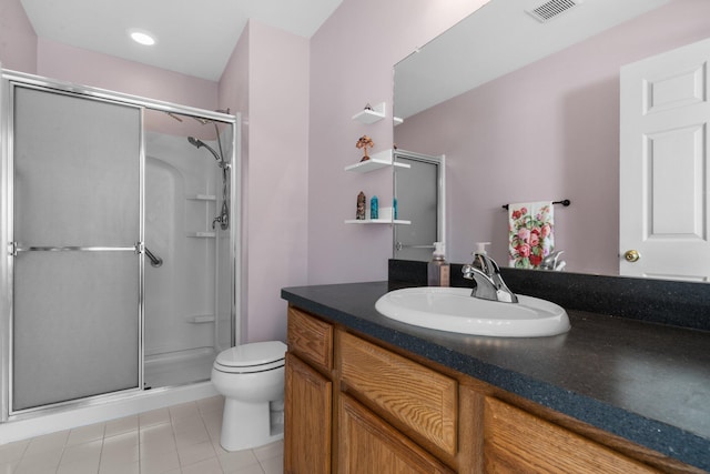 bathroom with toilet, vanity, visible vents, tile patterned floors, and a stall shower