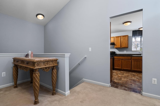 stairs featuring lofted ceiling, carpet, and baseboards