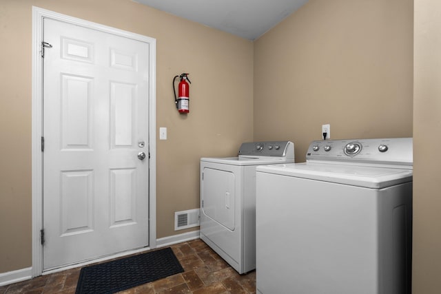 washroom featuring visible vents, stone finish flooring, separate washer and dryer, laundry area, and baseboards