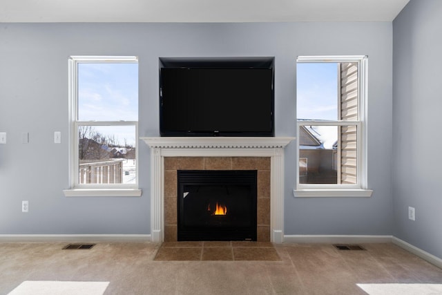 interior details featuring carpet floors, a tile fireplace, visible vents, and baseboards