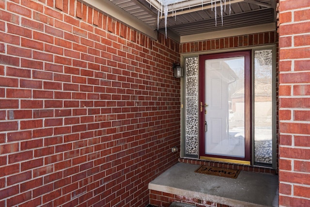 doorway to property featuring brick siding