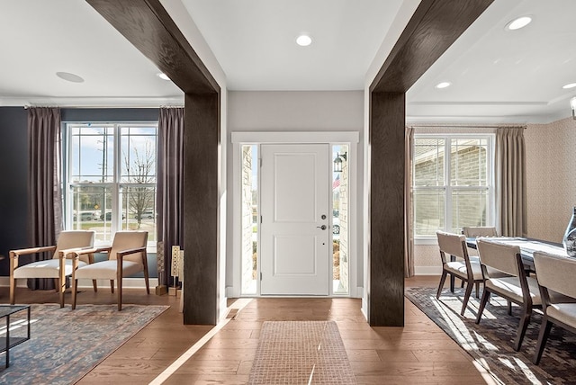 entryway with recessed lighting, wallpapered walls, baseboards, and wood finished floors