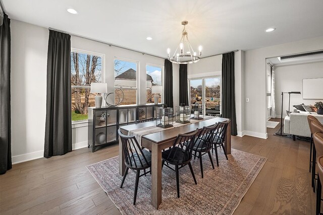 dining space with recessed lighting, a notable chandelier, baseboards, and wood finished floors