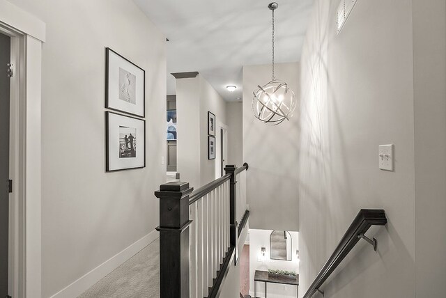 stairs with a notable chandelier, baseboards, and carpet flooring