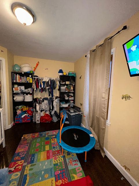 rec room featuring dark wood-style flooring and baseboards