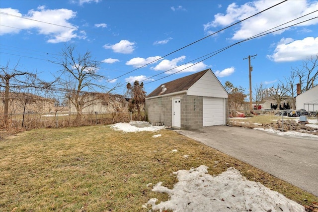 view of yard featuring driveway, a detached garage, and an outdoor structure