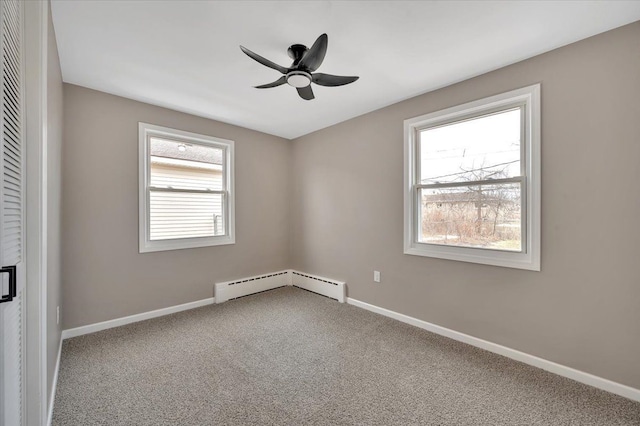 carpeted empty room featuring a baseboard heating unit, ceiling fan, and baseboards